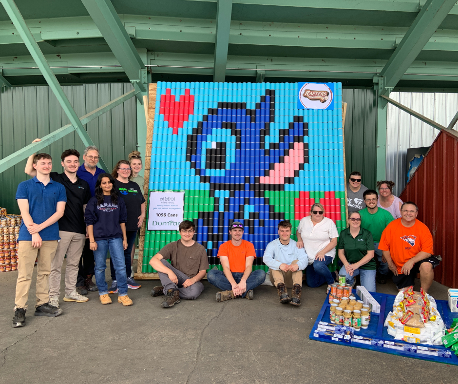 Domtar Team posing with their sculpture made of cans